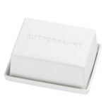 Weiche Butter in einer weißen Seifenschale mit dem Wort "BUTTERFAHRT" eingraviert.