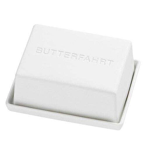 Weiche Butter in einer weißen Seifenschale mit dem Wort "BUTTERFAHRT" eingraviert.
