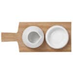 Hübsche weiße Keramik-Schale auf Holzbrett, ideal für Dips oder Saucen.