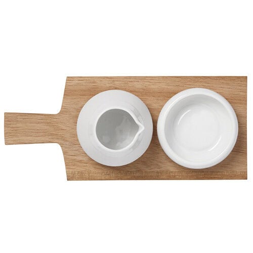 Hübsche weiße Keramik-Schale auf Holzbrett, ideal für Dips oder Saucen.