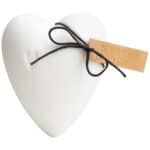 Herzförmiges weißes Geschenk mit Schleife und Grußkarte, ideal für besondere Anlässe.
