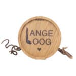 Ein Holzschild mit dem Schriftzug "LANGE OOG" und einem kleinen Herz, verbunden mit einem Zweig und.