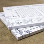 Notizbücher mit Meeresmotiven und Kalender, handgezeichnet, auf Holzuntergrund.