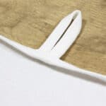 Weißes Stoff-Detail mit Träger, hochwertige Textilqualität, Nahaufnahme.