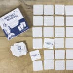 Maritimes Memo-Spiel mit Segelboot-Motiven, Karten und Spielbox auf Holzuntergrund.