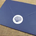Eine blaue Briefumschlag mit Muschel-Logo, ideal für elegante Korrespondenz und hochwertige Grußkart.
