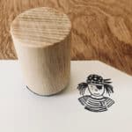 Hölzerner Stempel auf Papier mit Kinderzeichnung, kreative Bastelarbeit, handgemacht, Holzstempel, D.