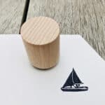 Hölzerner Holzstempel auf weißem Papier mit Segelboot-Design, für kreative Bastelarbeiten.