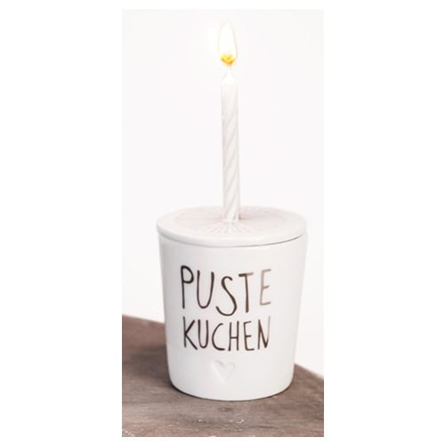 Ein Kerzenlicht in einem weißen Topf mit der Aufschrift "Puste Kuchen".