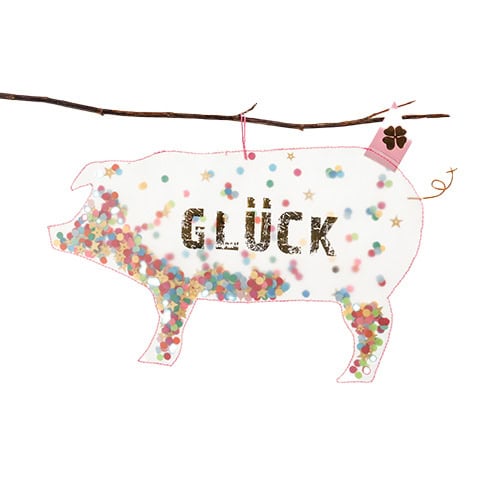 Glücksschwein aus buntem Konfetti mit dem Wort "GLÜCK" in der Mitte, aufgehängt an einem Zweig.