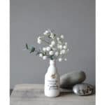 Blumen in weißer Vase mit Spruch, minimalistische Dekoration, natürliche Ästhetik, moderne Inneneinr.