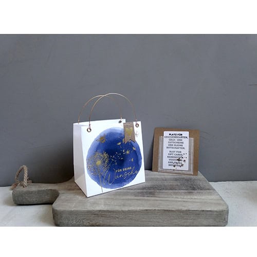 Einpacktasche mit Weihnachtsdesign und Geschenkkarte auf Holzplatte, festliche Dekoration, Geschenkv.