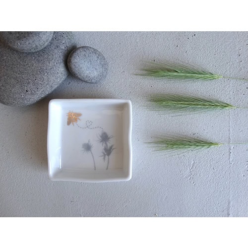 Sanfte Steine, weiße Schale mit Blumenmuster, grüne Gräser, minimalistische Dekoration, natürliche Ä.