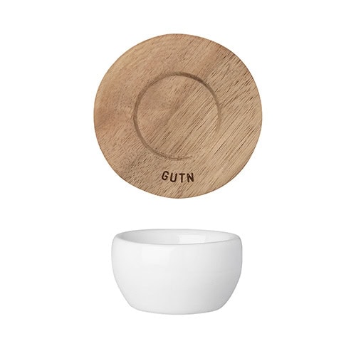 Hölzerner Teller mit Gravur "GUTN" und weißer Schale für stilvolle Tischdekoration.