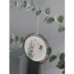 Ein minimalistischer Weihnachtsbaumschmuck mit Eukalyptuszweigen und einer runden Anhänger.