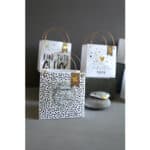 Hochwertige Geschenktüten mit goldenen Griffen und dekorativen Mustern, ideal für besondere Anläs.