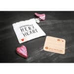 Herzförmiges Geschenk mit Karte und Säckchen, symbolisiert Freundschaft und Liebe.