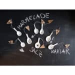 Marmelade, Salz, Kaviar – kreative Essensdekoration mit Löffeln und kleinen Fähnchen.