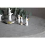 Himmlische Engel-Figuren aus Keramik auf grauem Stein, dekoratives Weihnachts- oder Winteraccessoire.