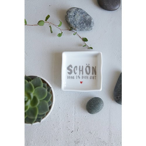 Hochwertige Dekoration mit Steinen, Pflanze und Spruchschale auf weißem Hintergrund.