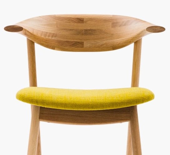 Moderner Holzstuhl mit gelbem Sitzkissen, stilvoll und bequem.