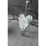 Ein leerer Glasflasche mit Herzanhänger, dekorativ und elegant, ideal für Geschenke oder Dekoratione.