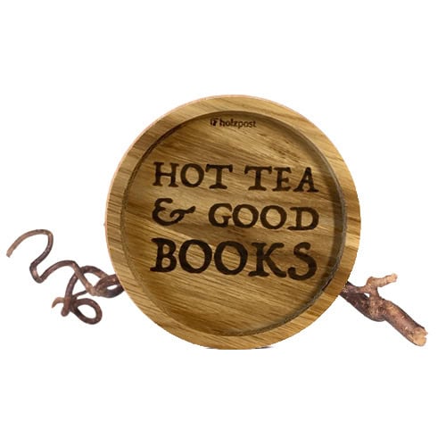 Heiße Tee Tasse mit Holzdeckel und Zweig, gemütliche Atmosphäre, ideal für Bücherliebhaber.