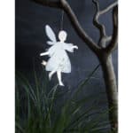 Hängender Engel aus Papier mit Flügeln, dekoriert im Garten unter einem Baum.