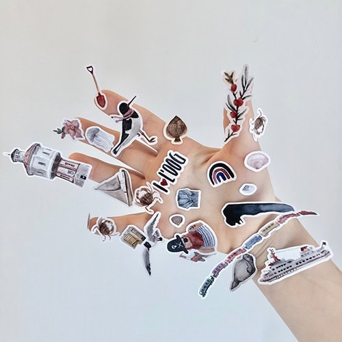 Ein handgefertigtes Collage mit verschiedenen kleinen Illustrationen und Symbolen auf einer weißen O.