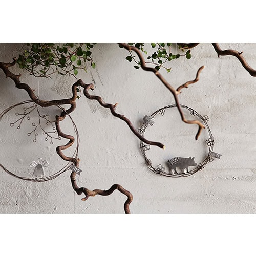 Kunstvolle Metall- und Drahtdekoration mit Tiermotiven an weißer Wand.