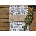 Der Zweig mit frischen Kräutern auf Holzuntergrund, kreative handgeschriebene Notiz im Hintergrund.