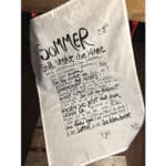 Sommer steht die Flitze, handgeschriebener Text auf Stoff, mit kleinen Bienenillustrationen.