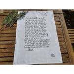 Der Text auf dem Bild ist ein handgeschriebener Gedicht- oder Zitattext auf einem weißen Tuch, das a.