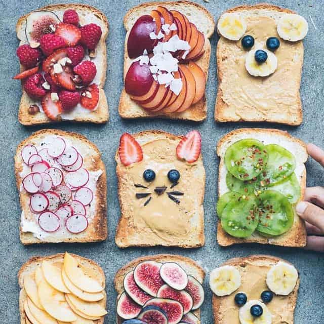 Bunte Frühstücks-Sandwiches mit Obst, Nüssen und kreativen Dekorationen.