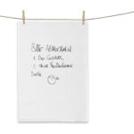 Hängendes Handtuch mit handgeschriebener Notiz und Smileygrafik, an Wäscheleine befestigt.