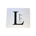L Buchstabe mit handgeschriebenem "Langeoog" auf weißem Stoffhintergrund.