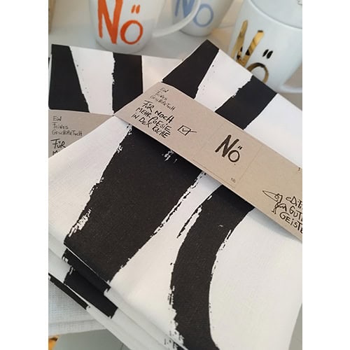 Schwarz-weiße Stoffe mit "No" Aufdruck und handgeschriebenen Notizen, kreative Textilgestaltung bei.