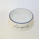 Hundenapf mit "Langoog" Schriftzug und blauer Rand, ideal für Haustiere.