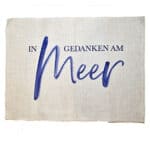 Dekoratives Stoffkissen mit "In Gedanken am Meer" Schriftzug in Blau.