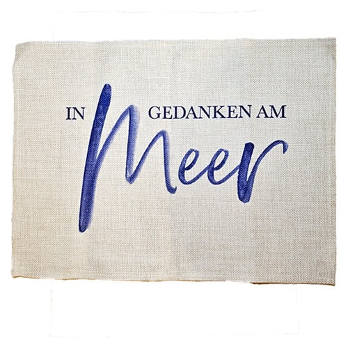 Dekoratives Stoffkissen mit "In Gedanken am Meer" Schriftzug in Blau.