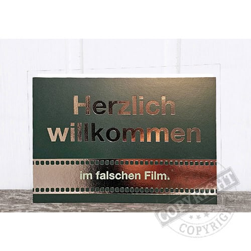 Herzlich willkommen im falschen Film - humorvoller Willkommensgruß auf Schultafel.