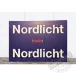 Nordlicht bleibt Nordlicht Schild mit rotem Wort "bleibt" auf dunklem Hintergrund.
