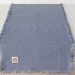 Handgefertigter blauer Wollteppich mit Fransen, hochwertiges Handwerksprodukt.
