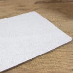 Hochwertige weiße Textilprobe auf Holztisch für Innenraumgestaltung und Design.