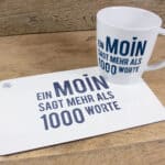 Ein MOIN sagt mehr als 1000 Worte, auf der Tasse und dem Papier sichtbar.