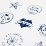 Herzförmiger Aufkleber mit "Mit Liebe" und maritime Symbole, ideal für Geschenke und Dekorationen.