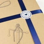 Geschenkverpackung mit blauer Schleife und Herz-Label, umweltfreundliche Verpackung.