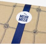 Hochwertige Verpackung mit Seil-Design und "Mehr Meer" Aufkleber, maritime Ästhetik, nachhaltige Prä.