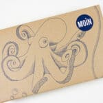 Vintageschachtel mit handgezeichnetem Oktopus und "MOÏN" Logo, nachhaltiges Verpackungsdesign, kreat.