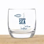 Frischer Wasser-Drink mit Meeresfischen und Vitamin Sea Schriftzug, gesundes Wasser, nachhaltige Was.
